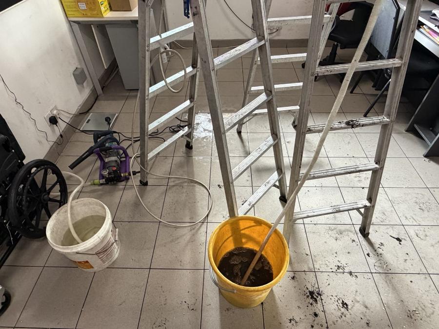 Bucket of dark wash water collected from one aircond unit